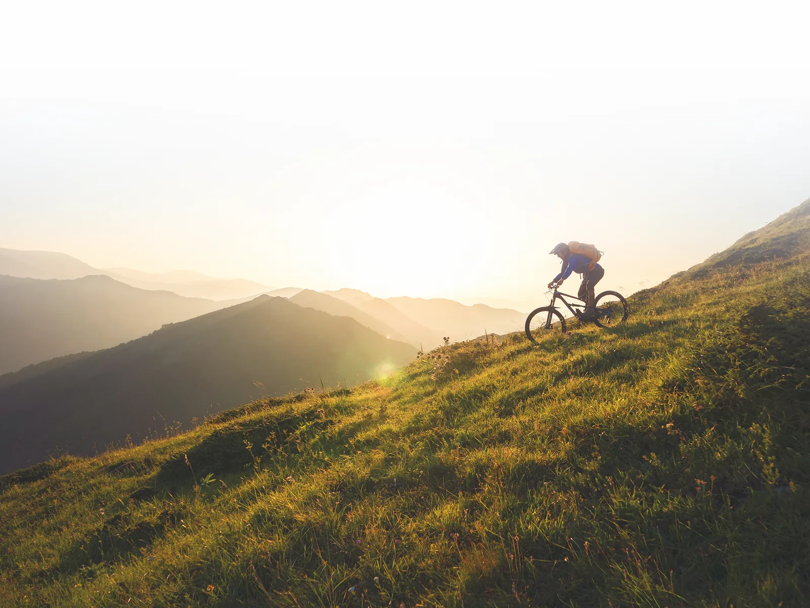 Radfahrerin in einer Hügellandschaft